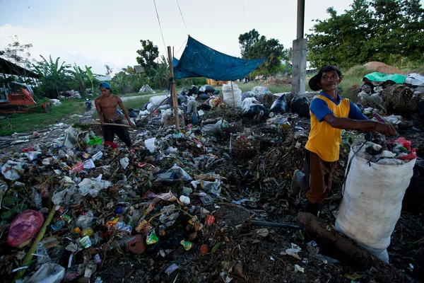 BALI, INDONÉSIA 11 DE ABRIL: Pobre da ilha de Java trabalhando em uma escavação na lixeira em 11 de abril de 2012 em Bali, Indonésia. Bali produziu diariamente 10.000 metros cúbicos de resíduos . — Fotografia de Stock